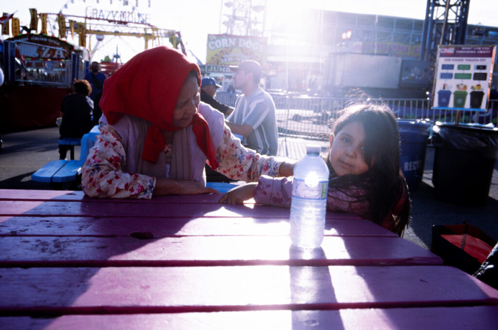 A grandmother and granddaughter at a picnic table at the CNE, the Ex, the Canadian National Exhibition.
