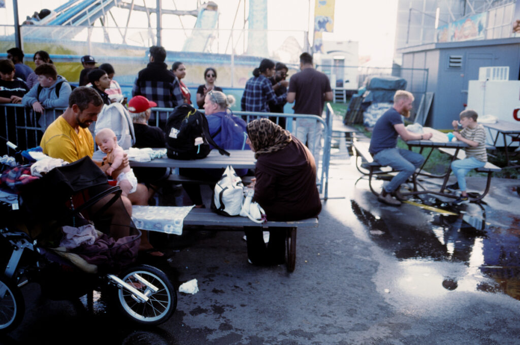 Families eating lunch at picnic tables at the CNE, the Ex, the Canadian National Exhibition.