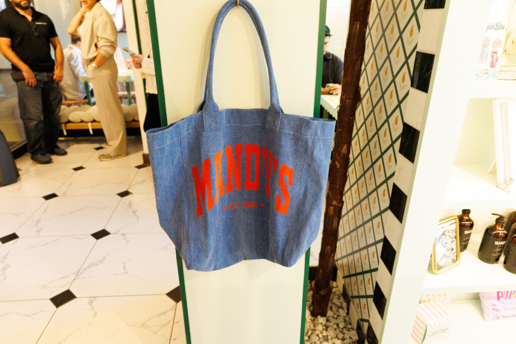 A denim Mandy's tote bag for sale, hangs on the wall at Mandy's Gourmet Salads in Yorkville, Toronto.