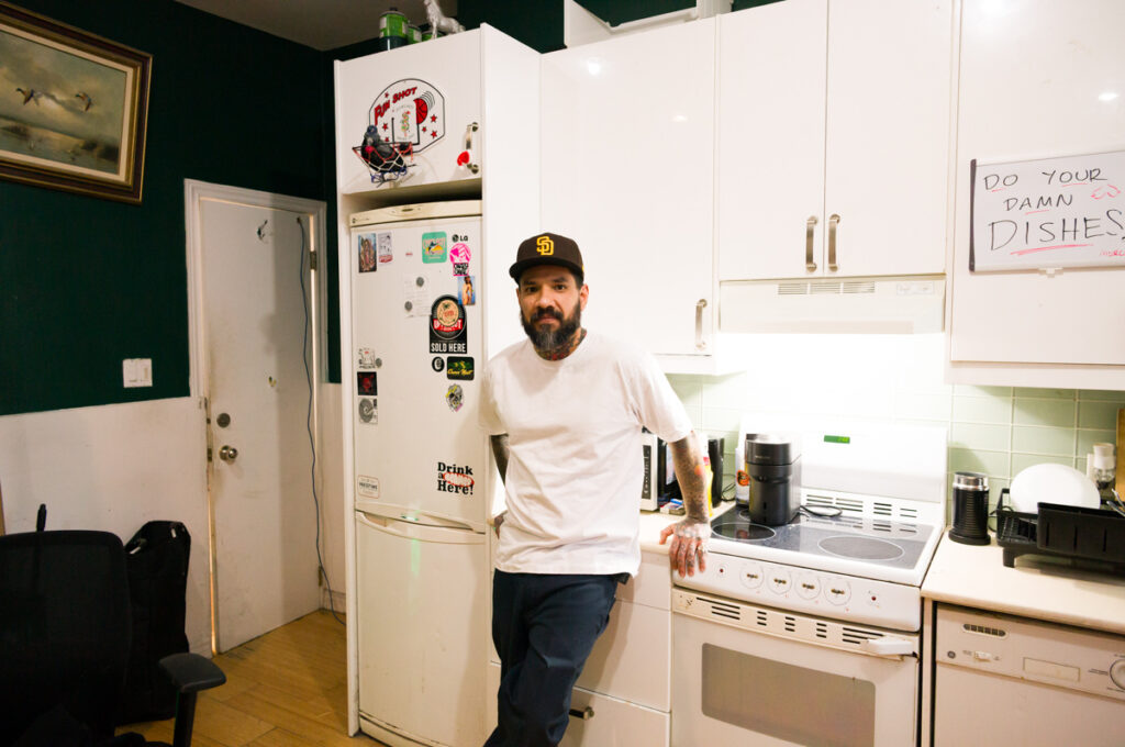 A portrait of Chino in the kitchen at Crows Nest Barbershop in Kensington Market in Toronto.