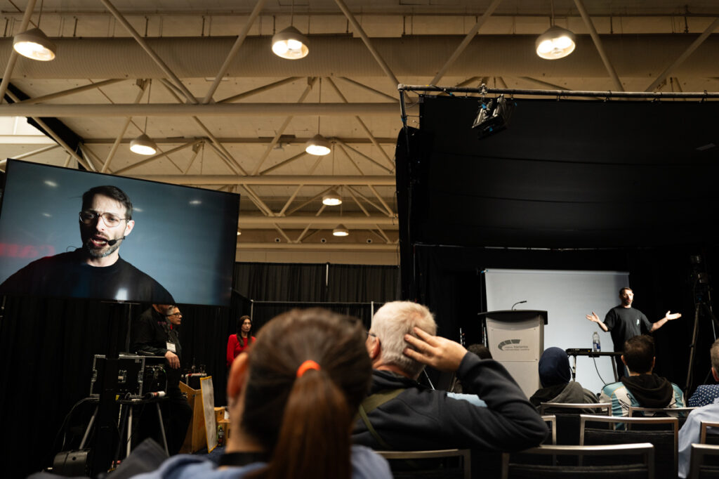 Cinematographer Dale Sood is on stage making a presentation at ProFusion Expo 2025 in Toronto.
