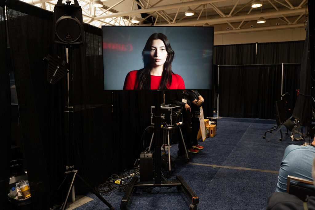 A model is being shown on a tv on a stand at the ProFusion Expo 2025 in Toronto.