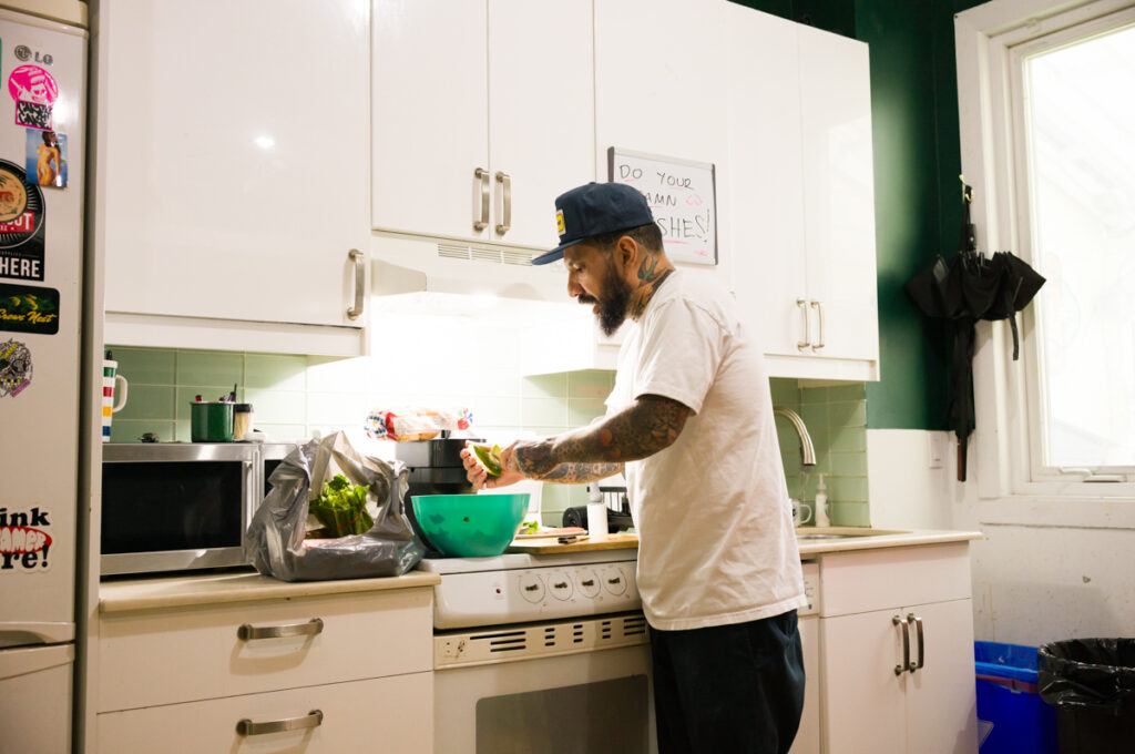 Chino is preparing an avocado at Crows Nest Barbershop in Kensington Market in Toronto.