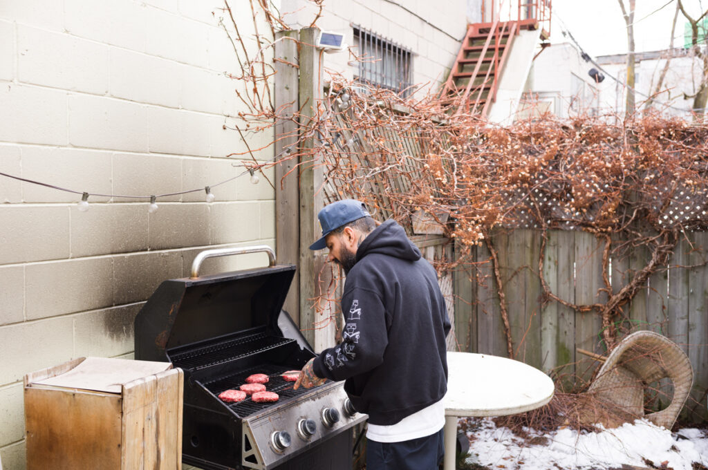 Chino is cooking on the bbq at Crows Nest Barbershop in Kensington Market in Toronto.